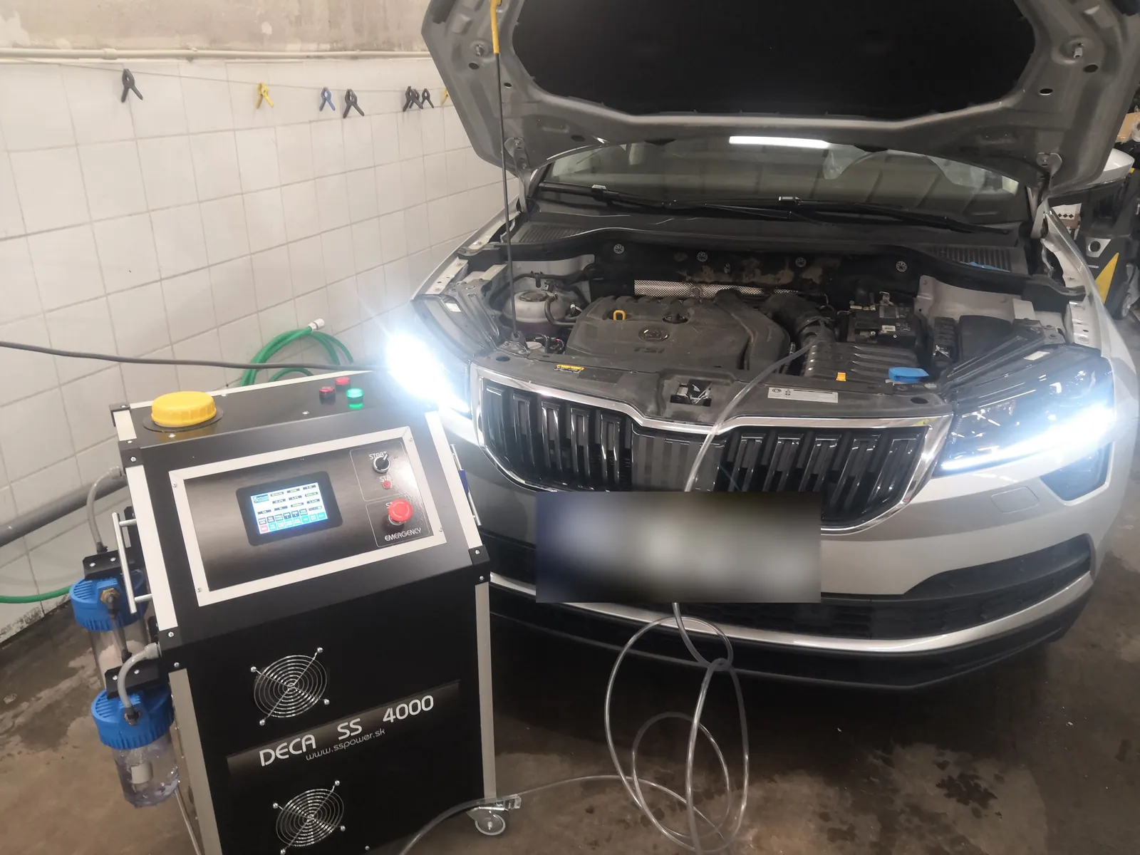 Přístroj DECA SS 4000 připojený k vozu Škoda s otevřenou kapotou v dílně